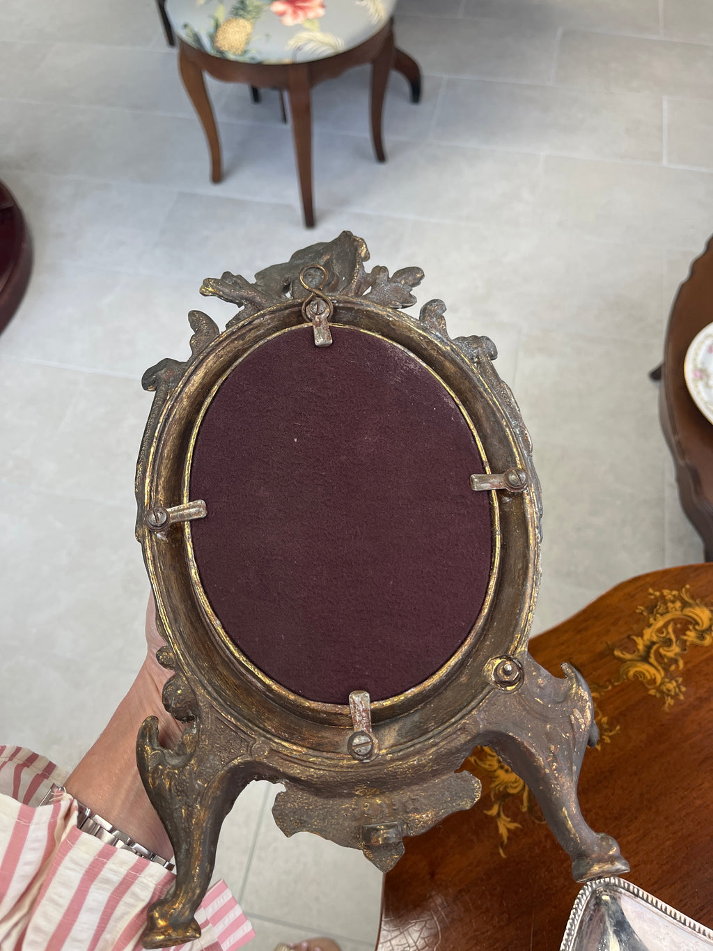 Antique cast iron oval mirror with cherub and ribbon motifs