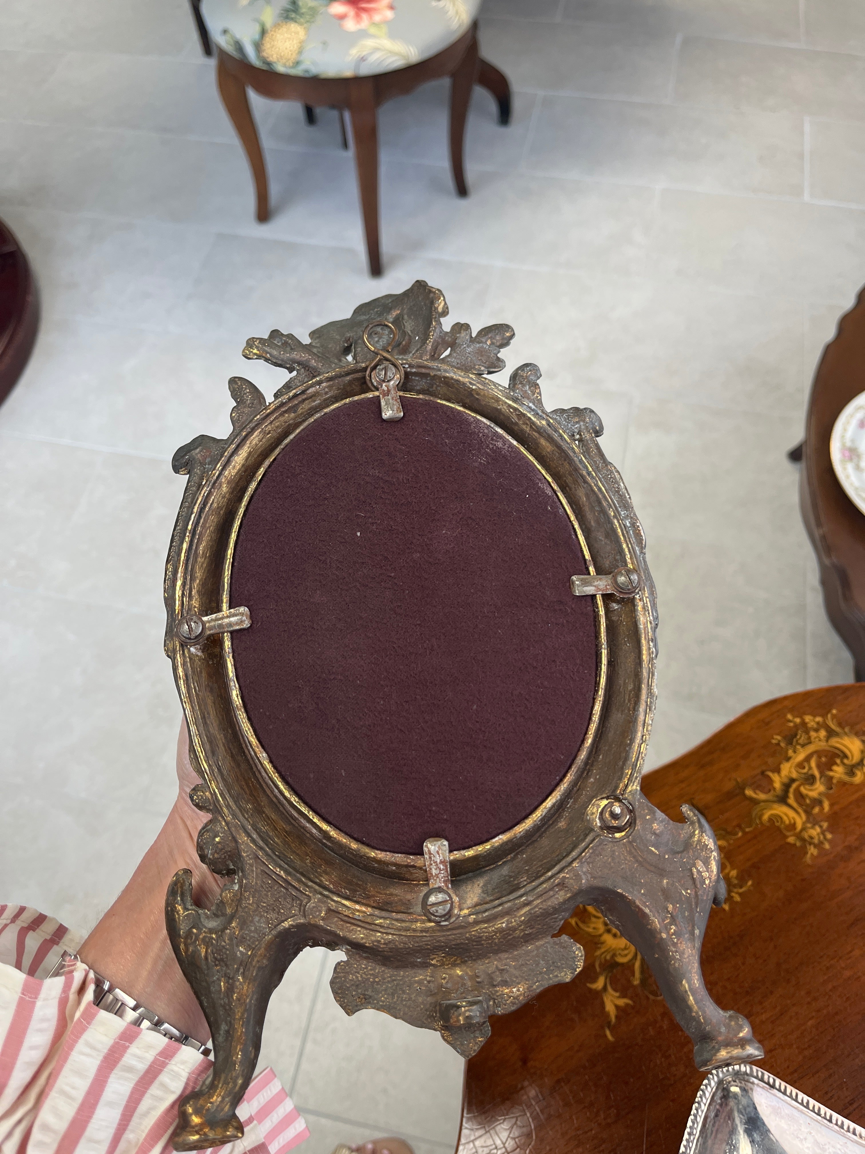 Antique cast iron oval mirror with cherub and ribbon motifs