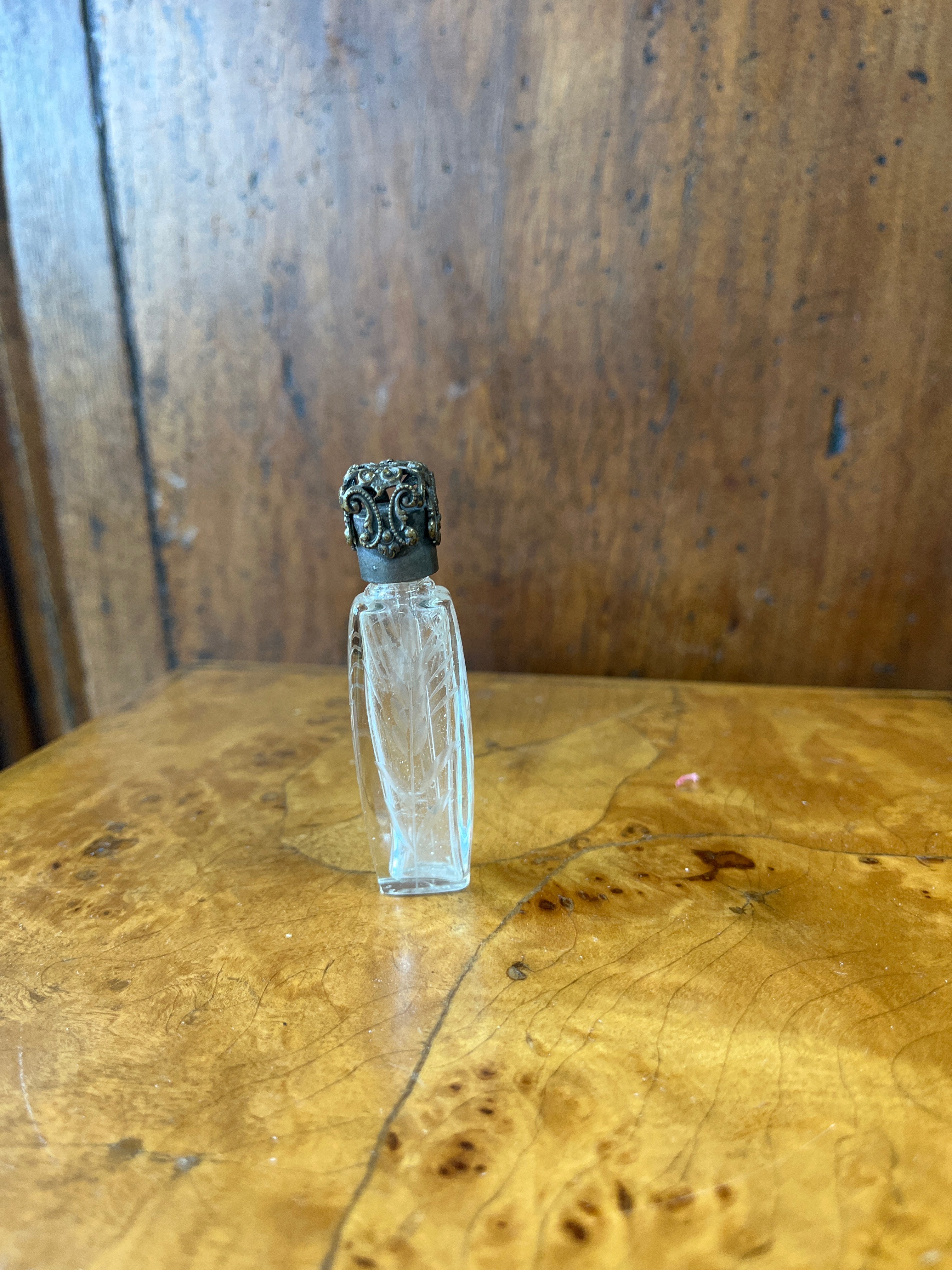 Vintage French etched glass perfume bottle with ornate silver caps.