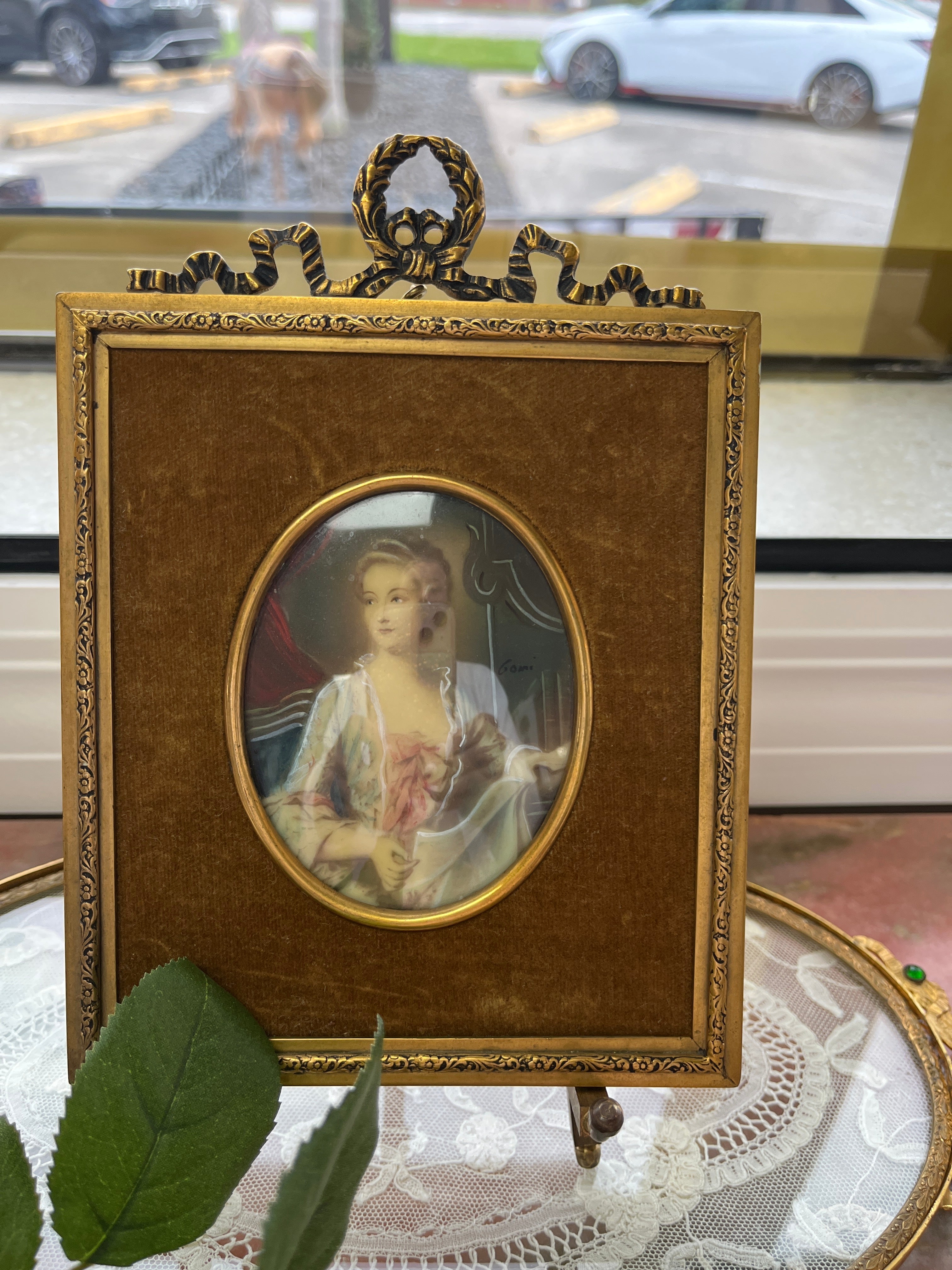 Hand-painted 18th-century miniature portrait of a woman, signed 'Gomi'.